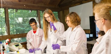 teacher and 2 campers in a bio lab